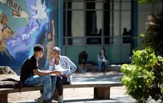 Two high school students sitting outside eating lunch