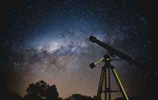 Telescope outdoors against a starry night sky
